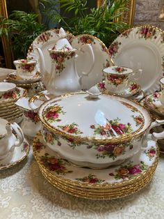 a table topped with lots of white and gold dishes