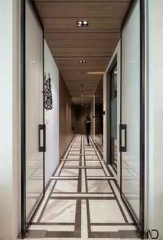 an empty hallway is shown with black and white tiles on the floor, along with glass doors