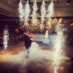 a bride and groom are dancing on the dance floor with sparklers in the air