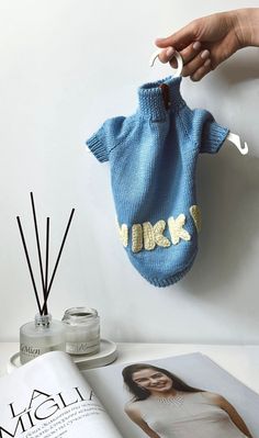 a person holding up a blue knitted bag