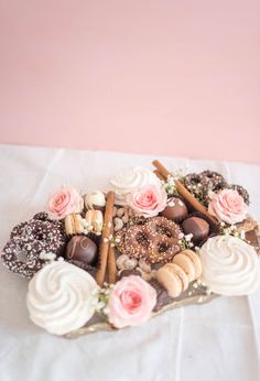 a heart shaped platter filled with lots of different types of cookies and pastries