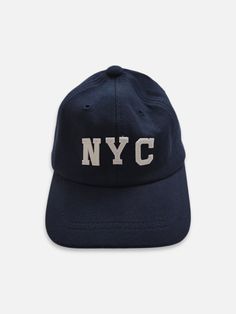 Baseball cap featuring NYC embroidering and strap back with belt buckle. Navy Dad Hat With Embroidered Logo And Curved Bill, Navy Hat With Embroidered Logo And Curved Visor, College Baseball Cap With Embroidered Logo, Navy Dad Hat With Embroidered Logo, Curved Brim Dad Hat With Embroidered Logo For College, College Dad Hat With Embroidered Logo, Adjustable Baseball Cap For College, Adjustable Six-panel Baseball Cap For College, Adjustable Curved Brim Dad Hat For College