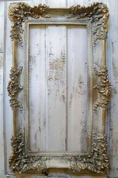 an ornate gold frame hanging on the side of a wooden wall with peeling paint and chipped paint