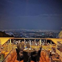 an outdoor dining area overlooking the city at night