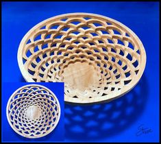 a wooden bowl with an intricate design in the center and a circular basket below it