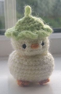 a small crocheted bird sitting on top of a window sill