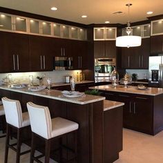 a large kitchen with brown cabinets and marble counter tops