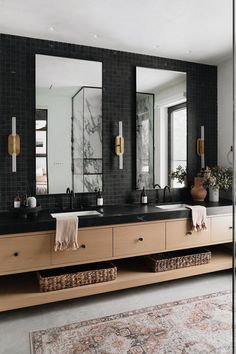 a bathroom with two sinks, mirrors and rugs in front of the sink area