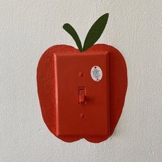 an apple shaped light switch cover on the wall