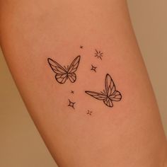 two butterflies flying in the sky with stars on their backs and legs, tattoo style