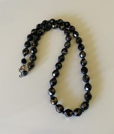 This classic nice quality 18 inch 7mm faceted jet black bead necklace is a classic closet basic. The faceted beads have seed bead spacers and wire strung smaller beads near the clasp to keep the back from being bulky. The necklace is sturdy with a gold tone lobster claw closure. The necklace is a classic inches long. This necklace is a great closet basic in wonderful vintage condition. The beads have a bright carnival sheen. I specialize in finding fun wearable vintage jewelry. Please browse my Classic Faceted Beads Necklace For Gift, Classic Black Beaded Necklaces, Black Necklace With Oval Spacer Beads, Formal Adjustable Beaded Necklace With Faceted Beads, Black Faceted Round Beaded Necklaces, Black Faceted Beaded Necklaces, Black Jewelry With Faceted Oval Beads, Formal Black Beaded Necklace With Faceted Beads, Black Jewelry With Oval Faceted Beads