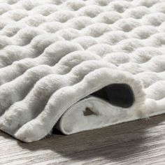 a close up of a white rug on a wooden floor