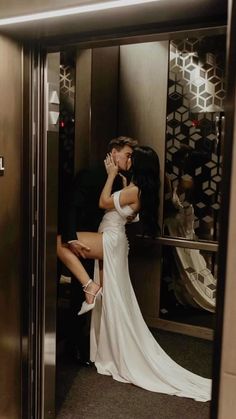 a man and woman kissing in an elevator