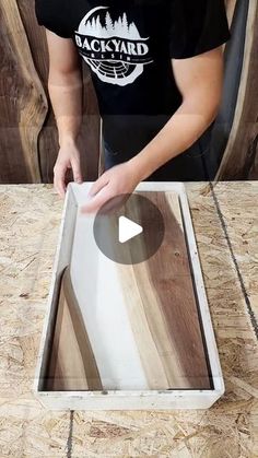 a person standing over a wooden table with a glass window on it's side