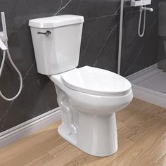 a white toilet sitting in a bathroom next to a shower head and hand showerhead