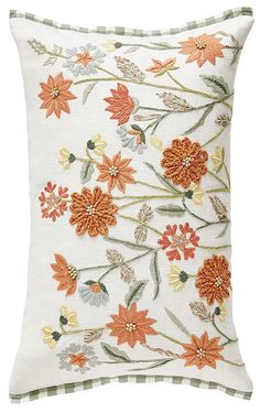 a white pillow with orange flowers on it