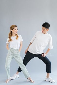 a man and woman are posing for a studio photo in front of a gray background