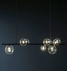 four lights hanging from the ceiling in a dark room with black walls and flooring