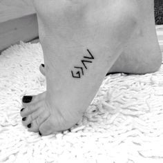 black and white photo of someone's foot with the word love tattooed on it