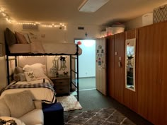 a bedroom with bunk beds and lights on the ceiling, in front of a door