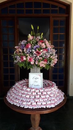 a table topped with lots of candy covered in pink and purple flowers next to a doorway