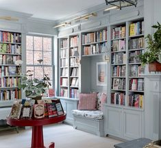 a room filled with lots of books next to a window