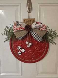 a red door hanger decorated with christmas decorations and bows on it's front door