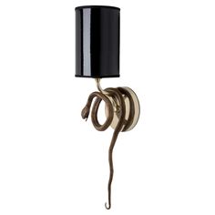 a lamp with a snake wrapped around it's base and a black shade on top