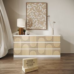 a white and beige dresser sitting on top of a wooden floor next to a lamp