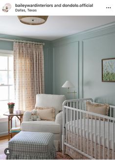 a baby's room with blue walls and white furniture