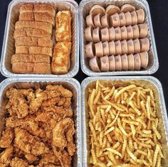 four plastic trays filled with different types of food including chicken, french fries and hot dogs