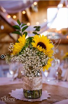 sunflowers and baby's breath in a mason jar at a wedding reception