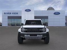 a white truck is parked in front of a ford dealership with the words river view on it