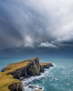 an ocean view with storm clouds over the cliffs