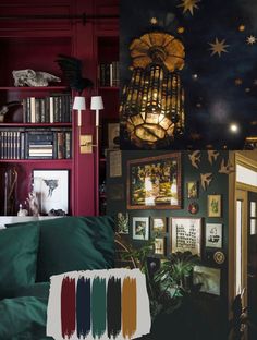 a living room filled with lots of furniture and paintings on the wall next to bookshelves