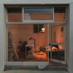 an open window shows the inside of a room that has been renovated and is lit up