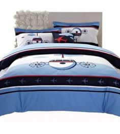 a bed with blue and white comforters and pillows