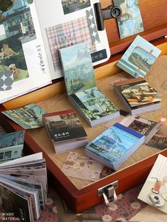 many books are on the table with pictures and papers scattered around them, including one that is open