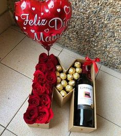 a heart - shaped balloon, wine bottle and roses are on the floor next to a valentine's day box