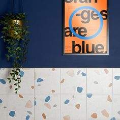 a blue and white tiled wall with an orange poster hanging on it's side