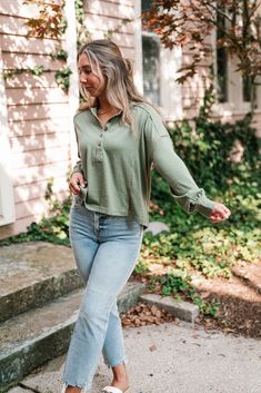 The Keeping It Cozy Long Sleeve Henley Top is a versatile, relaxed-fit Henley with a comfortable and laid-back style. The sage green color is perfect for transitioning into cooler months, while the exposed seams add a touch of rugged charm. It features a Henley-style neckline with four buttons, offering flexibility in how it can be worn. The dropped shoulder design and slightly cropped length make it both flattering and easy to pair with high-rise jeans or joggers. Fabric: 64% Polyester 32% Cott Khaki Tops For Fall Loungewear, Casual Olive Long Sleeve Tops, Comfortable Green Fall Tops, Comfortable Green Tops For Fall, Green Tops For Casual Fall Gatherings, Green Tops For Loungewear In Fall, Green Top For Loungewear In Fall, Casual Olive Tops For Winter, Green Comfy Tops For Fall