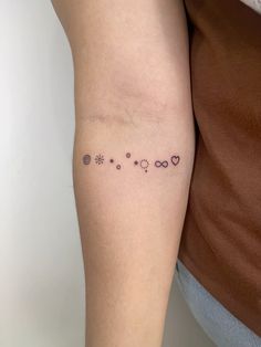 a woman's arm with small tattoos on it