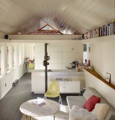 a living room filled with furniture next to a kitchen