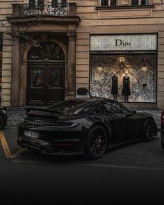 a black sports car parked in front of a building