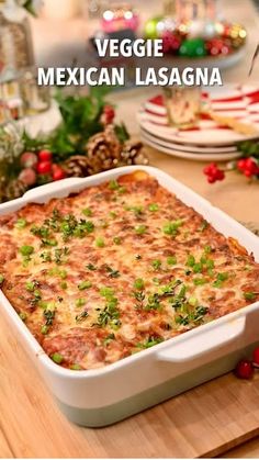 mexican lasagna in a white casserole dish on a wooden cutting board