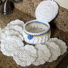 a crocheted baby hat and booties sitting on top of a sink