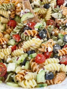 a bowl filled with pasta salad on top of a red and white checkered table cloth