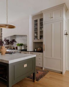 a large kitchen with an island in the center and cabinets on both sides, along with wooden flooring