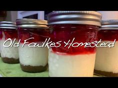 four jars filled with food sitting on top of a green table cloth covered in white and red liquid