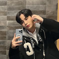 a young man taking a selfie in front of a mirror with his cell phone